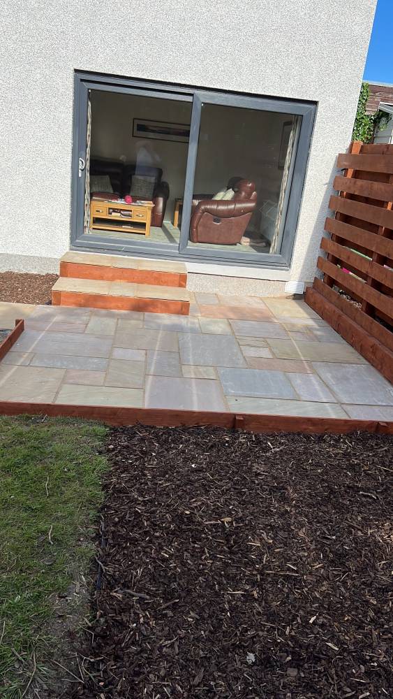 Sandstone patio with slatted timber privacy screen and step