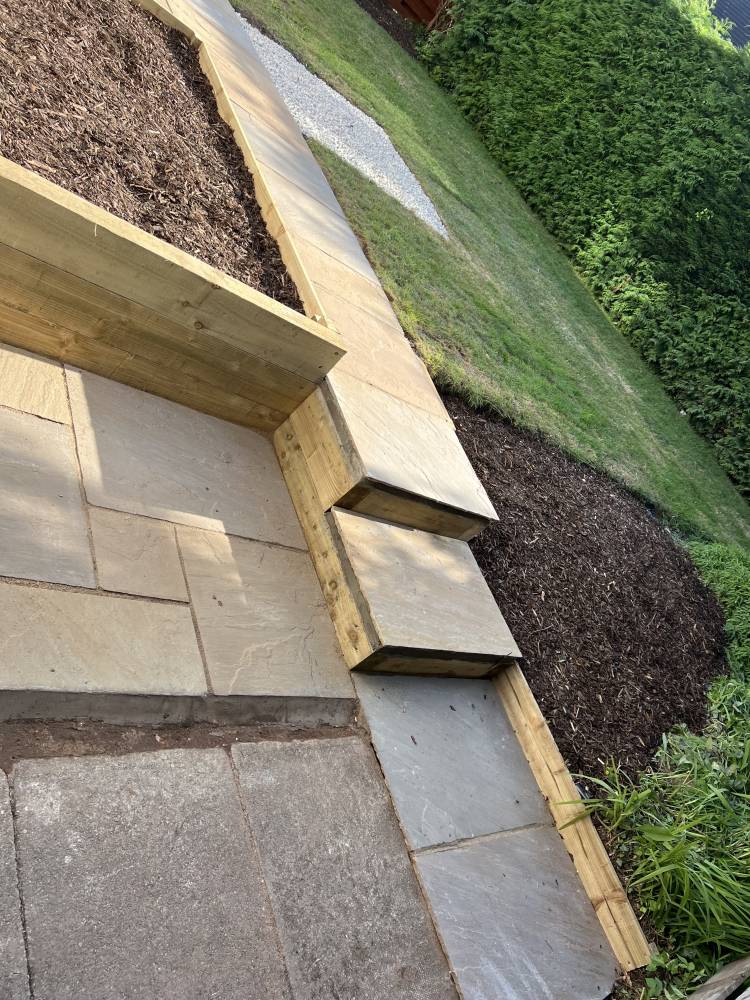 Sandstone steps with timber sleeper retaining wall in garden