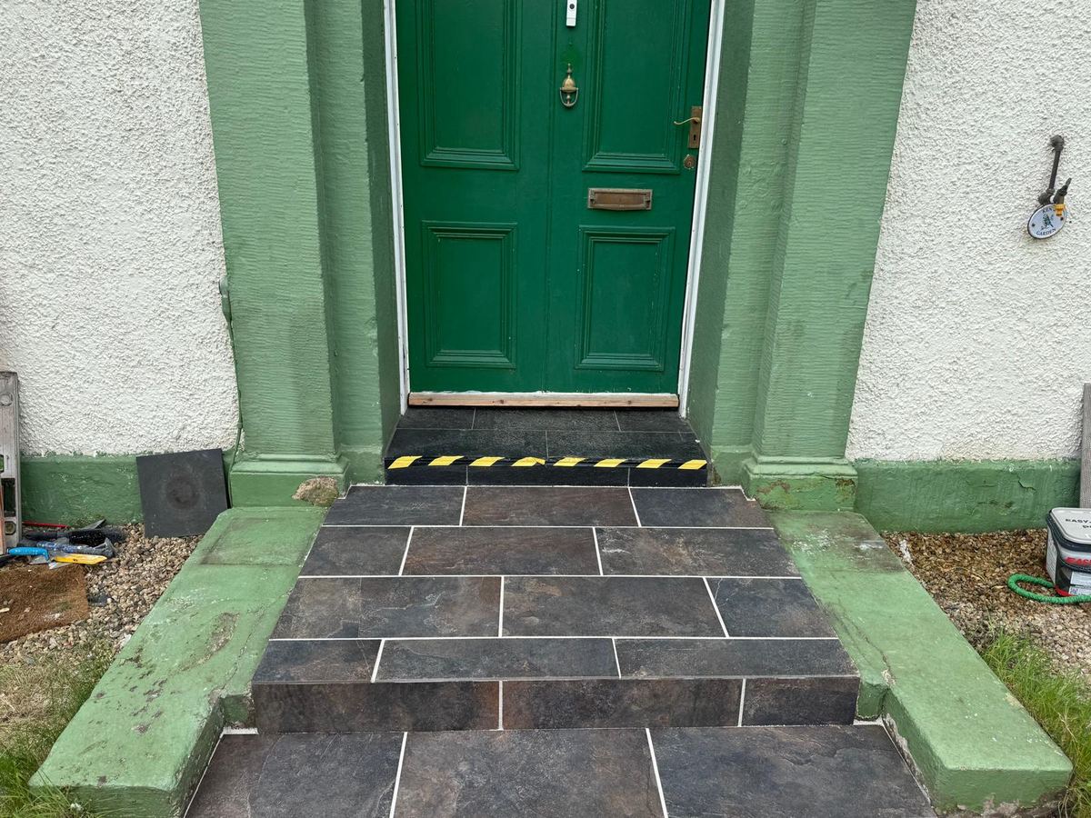 Completed slate-effect tiled front steps up to the front door