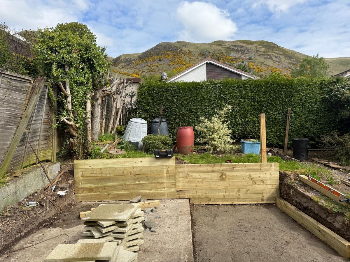 Timber sleeper retaining wall built ahead of porcelain patio laying