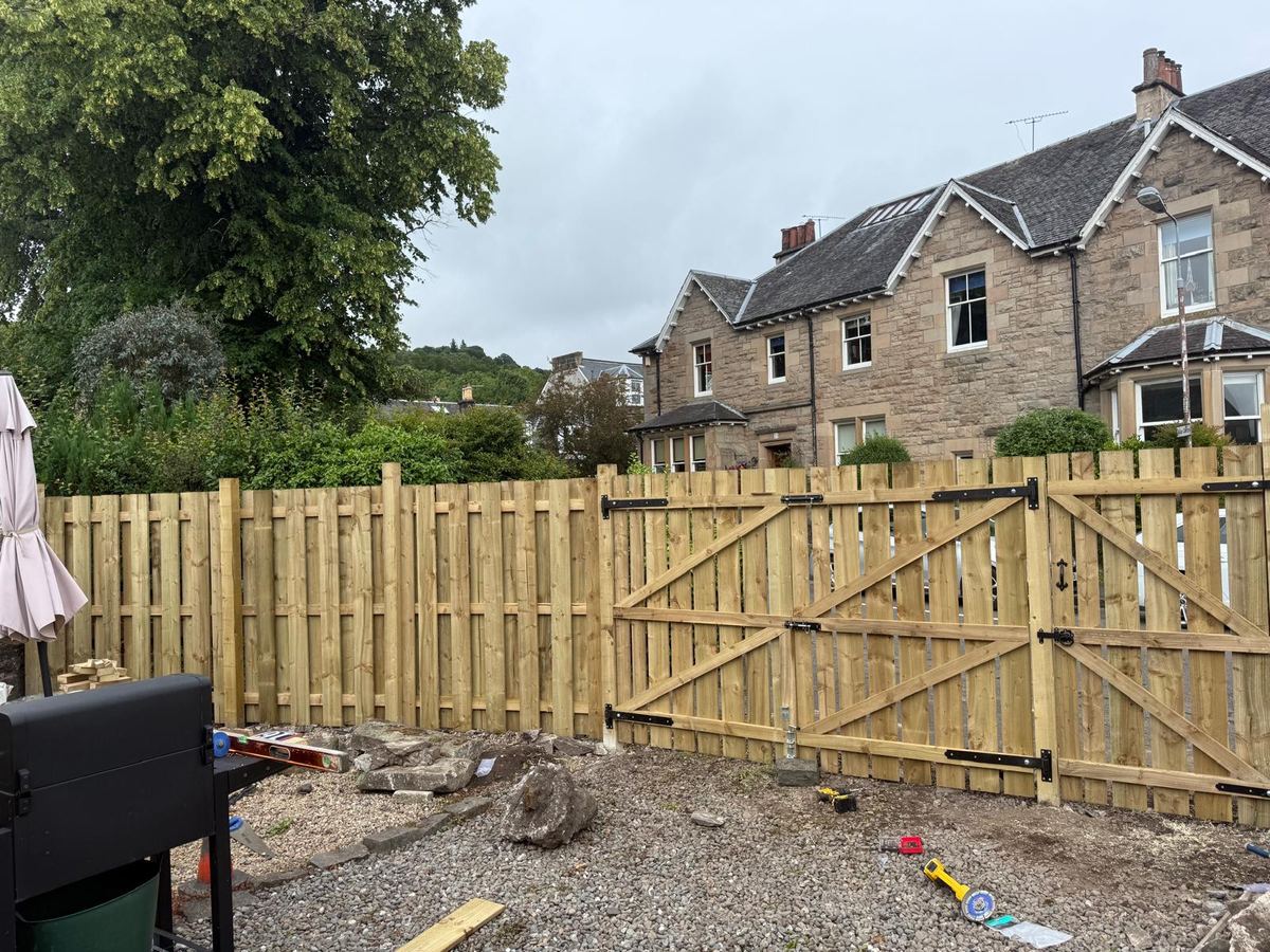 Timber fence with double driveway gates