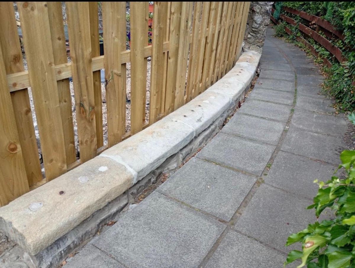 New timber fence on a stone-capped dwarf wall following a curved lane